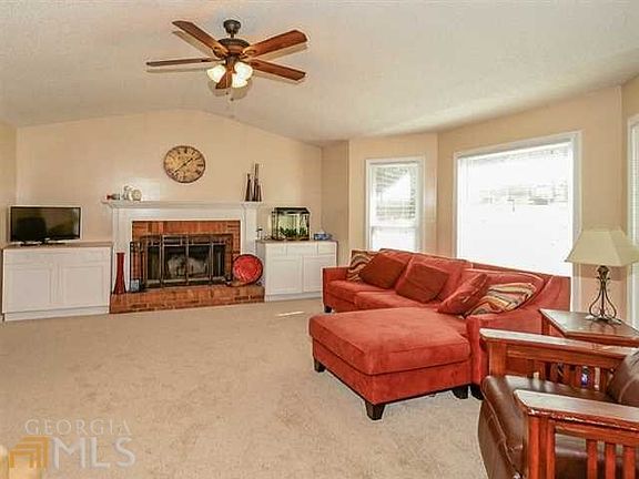 Gather around cozy brick fireplace flanked by built-ins