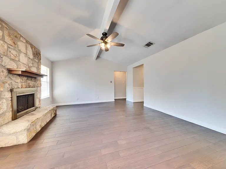 Spacious Living Room: Relax and unwind in the expansive living room complete with vaulted ceilings and a cozy fireplace, creating a warm and inviting atmosphere.