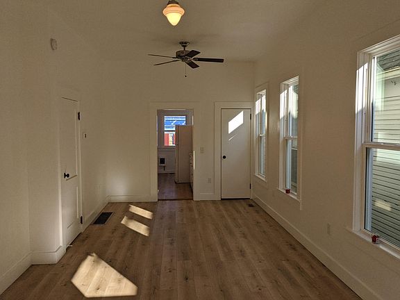 Living Room. Photo taken looking north. The kitchen is located through the open door. To the right is the door going upstairs. To the left is the door going to the North bedroom
