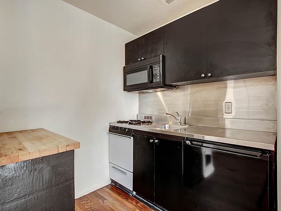kitchenette with dishwasher, stove, microwave and fridge