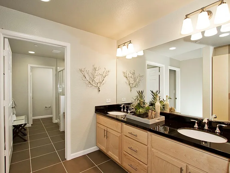Townhome bath with oak cabinetry and hard surface flooring