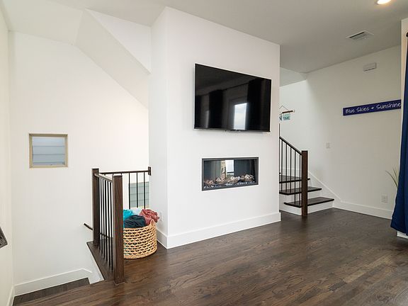 Spacious living room with vibrant pops of color, a large L-shaped couch, cozy fireplace, and TV_perfect for lounging and unwinding.
