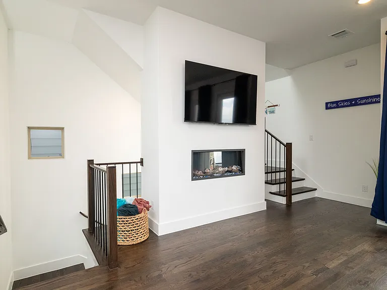 Spacious living room with vibrant pops of color, a large L-shaped couch, cozy fireplace, and TV_perfect for lounging and unwinding.