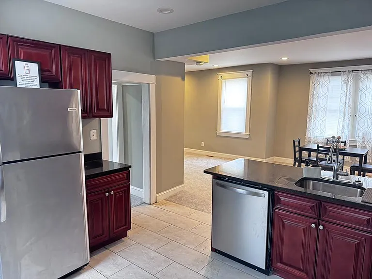 Open kitchen with ample cabinetry, stainless appliances, and a breakfast peninsula flowing into the dining area.