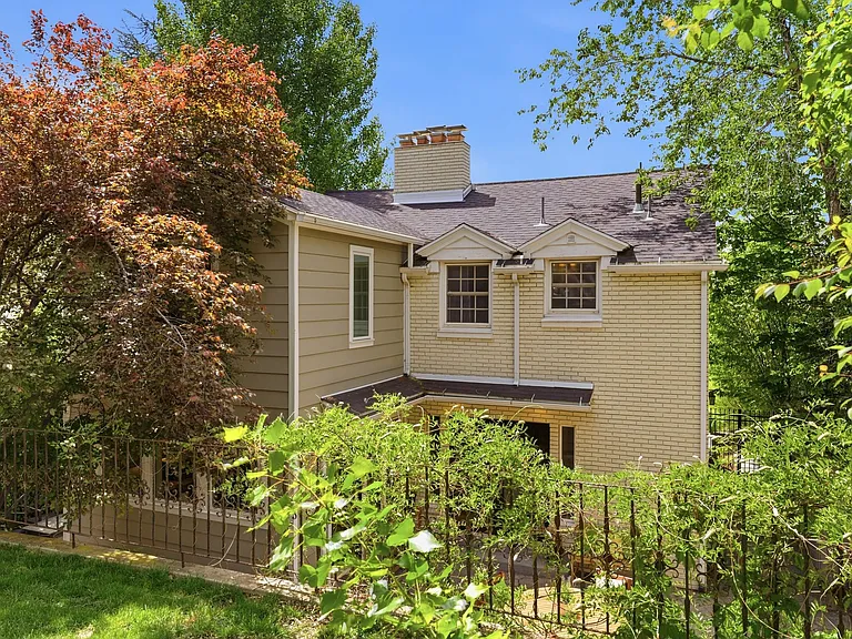 Private back patio and back of the house with mature trees and peaceful garden space.