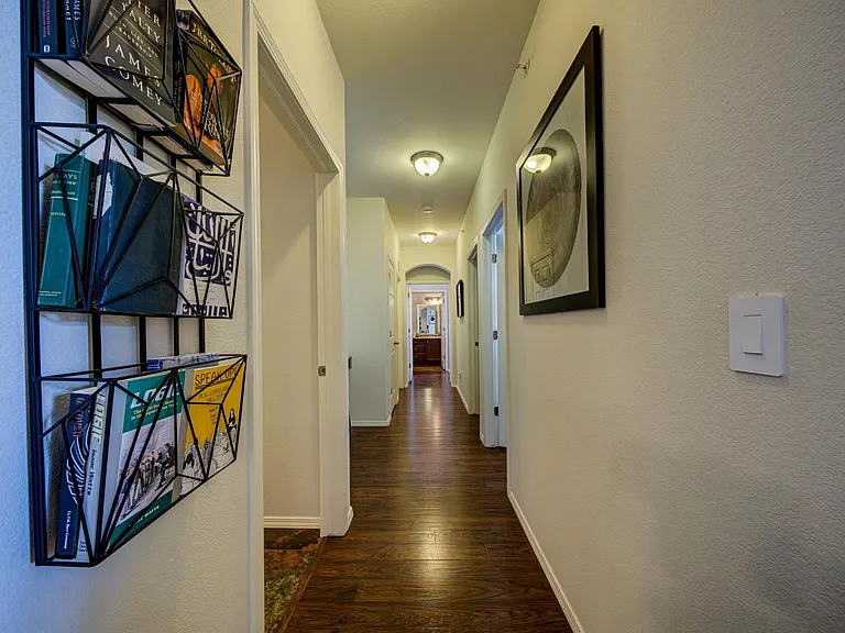 Hallway to two bedrooms on the right, master suite straight ahead, desk area to the left, & laundry room to the left.