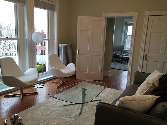 The living room has modern furnishings and tons of light fro
