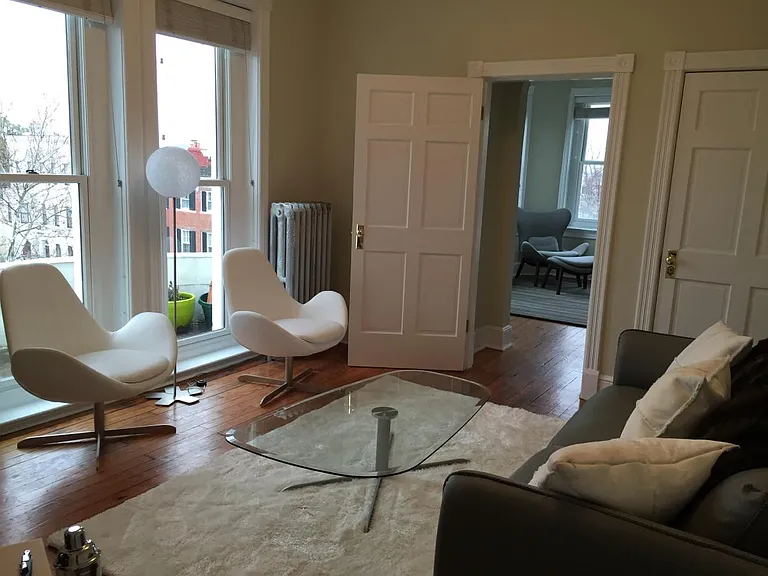 The living room has modern furnishings and tons of light fro