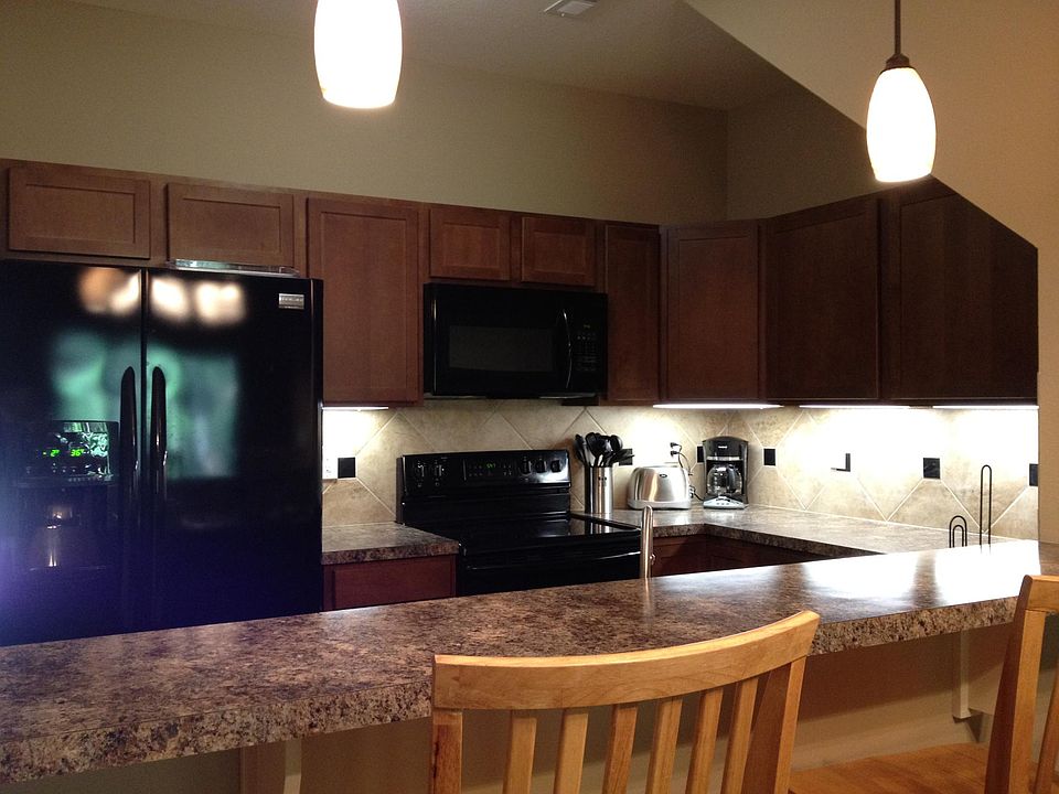 Kitchen with bar area, under counter lighting and lazy susan. Refrigerator has ice maker and water dispenser