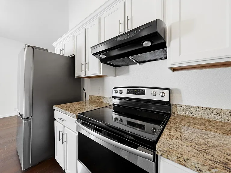 Kitchen features granite counters, ample cabinet storage, and a full appliance set with electric range and refrigerator.