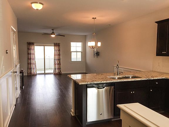 View from kitchen into dining area and living room. TV is ready to be mounted to the wall