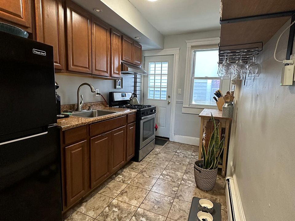 Kitchen with floating shelves and door to back alley exit