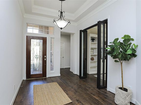 Double crown molding and new flooring great you upon entry. All fresh interior paint in neutral to work with your needed color scheme. Door to garage and sides to laundry/work room. Black iron sliding doors to remodeled study.