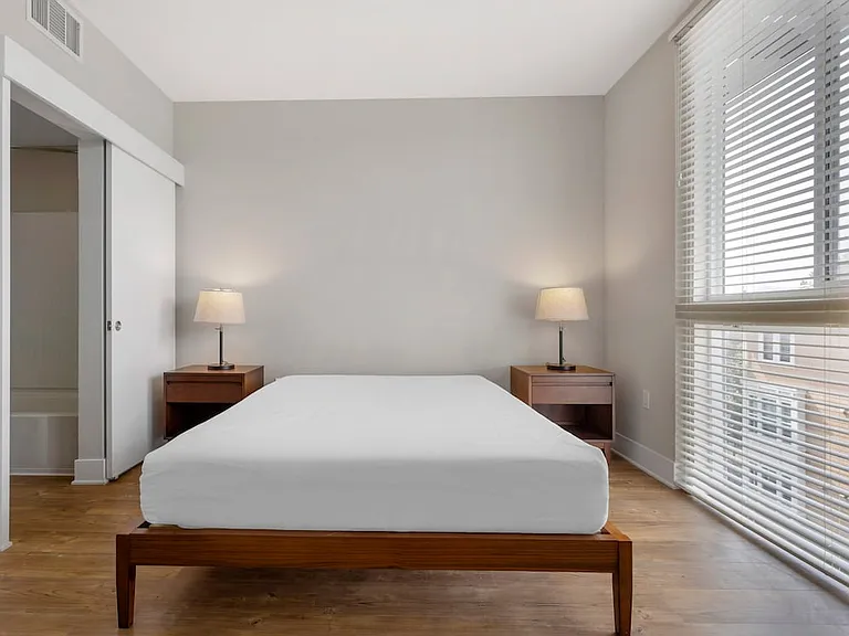 Furnished+ apartment homes feature queen bed with mattress, dresser, nightstands, and lamps (Representative Image exact items and style of furnishings may vary)