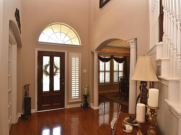 Elegant entry offering a beveled glass front door, hardwood floors, two story high ceilings and acce