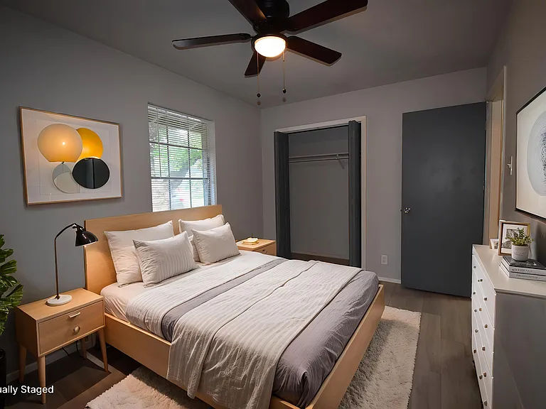 Virtually staged primary bedroom with a ceiling fan.