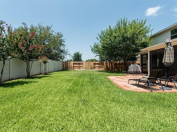 There is a raised garden bed with separate sprinkler system and timer. Garden includes peppers, tomatoes, green beans, jalapeos, eggplant, carrots, and potatoes. Beautifully landscaped trees!