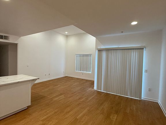 Open concept dining and living area with high ceilings and balcony.