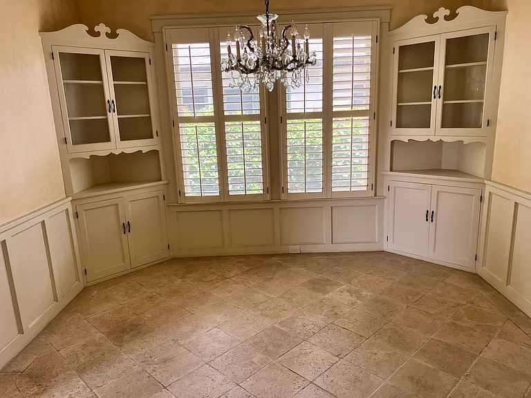 Dining room - ample sized, crystal chandelier, original built-ins, wainscotting and travertine tile flooring.