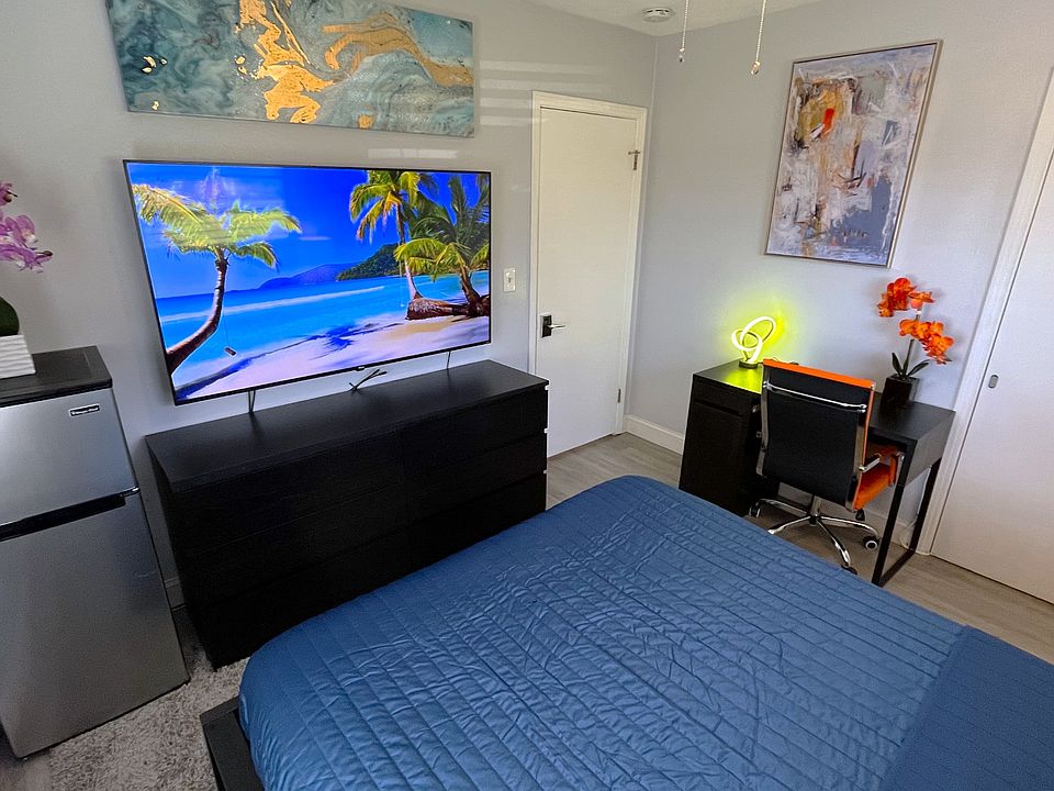 Room 2 features: Queen bed, dual night stands, table lamps, ceiling fan, mini fridge, desk, 65in TV
