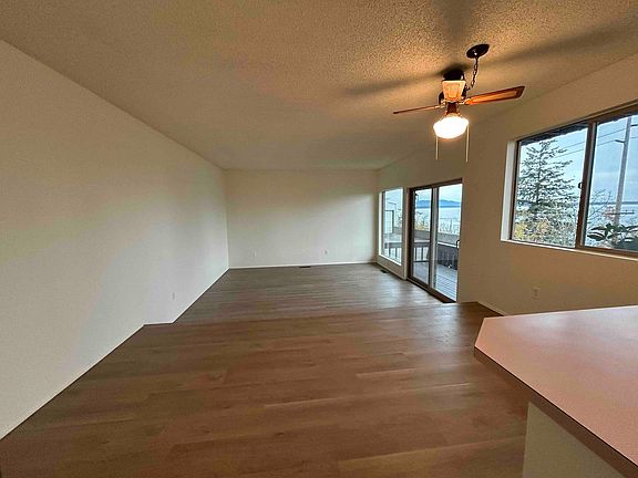 Open concept kitchen/dining/sunken living room with deck access