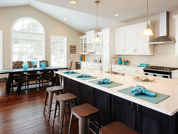 Kitchen and keeping room areas in the Dartmouth floorplan - white cabinetry, quartz countertops, and