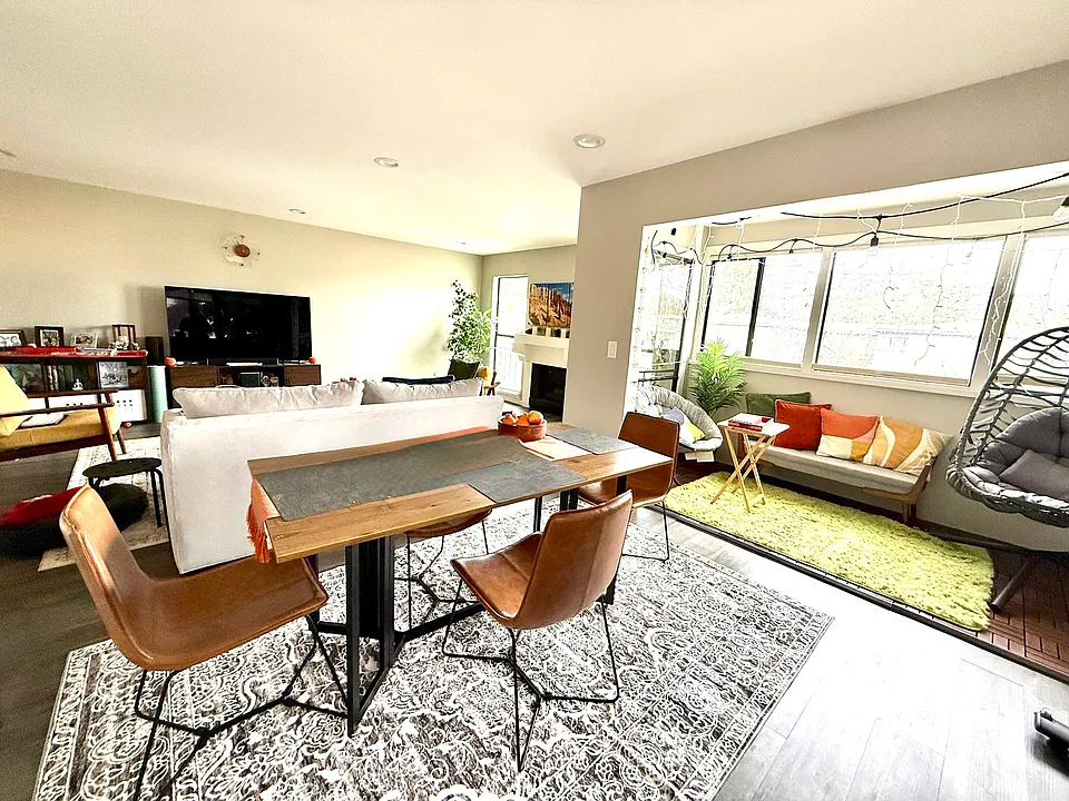 Living Room and Dining Room with windows surrounding on two sides and facing a lovely Redwood tree