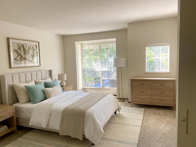 Staged for layout visualization; unit comes unfurnished" Master bedroom showing 2 different bed orientations.