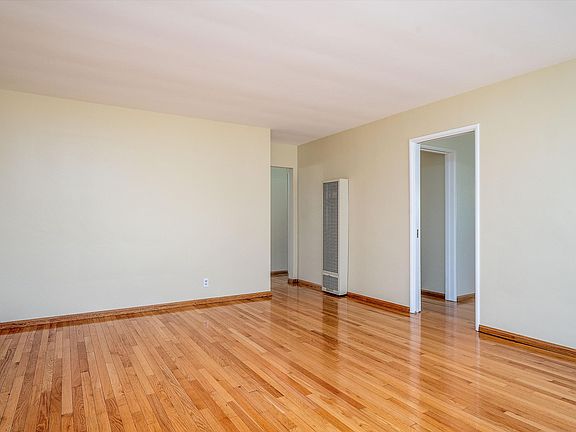 Light and bright living room with dual pane windows & wall heater