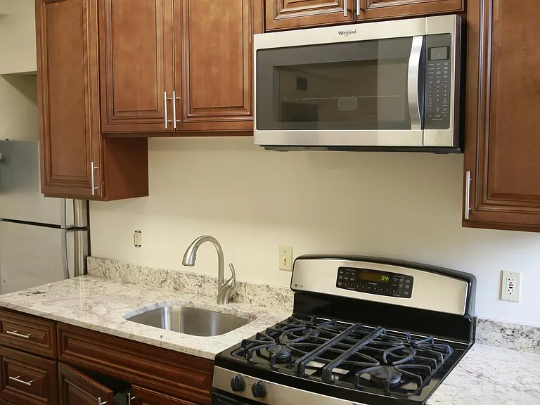 kitchen, microwave, gas stove, wood cabinets, new refrigerator.