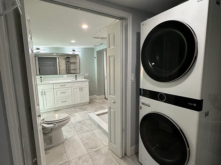 high tech washer / dryer in walk in closet and view to master bathroom