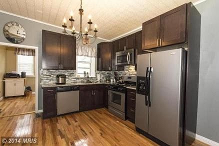 Large Kitchen - stainless appliances - glass back splash