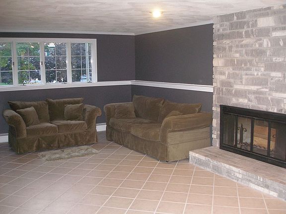 Lower Level Family Room With Fireplace and Guest Half-Bath.