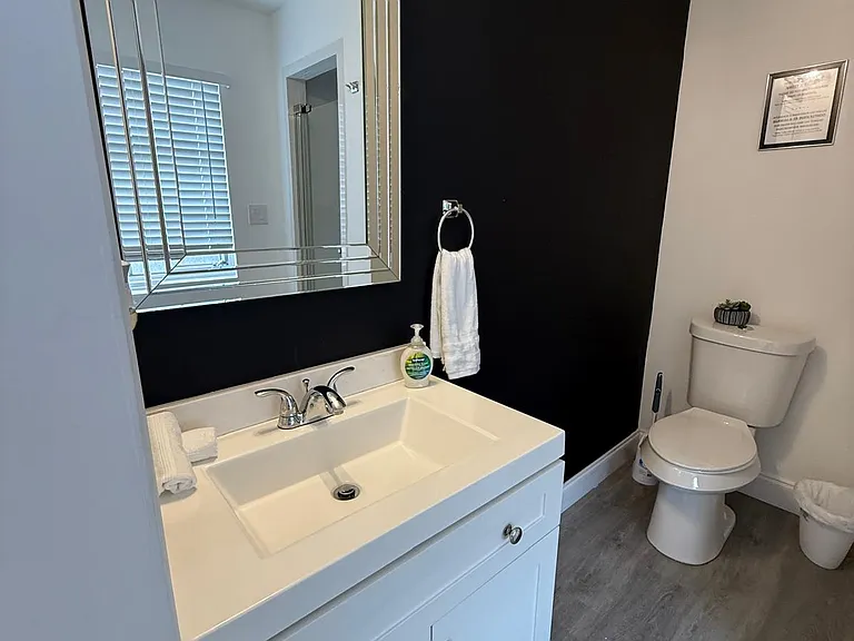 Stylish bathroom featuring shower, toilet, sink, and fresh towels.