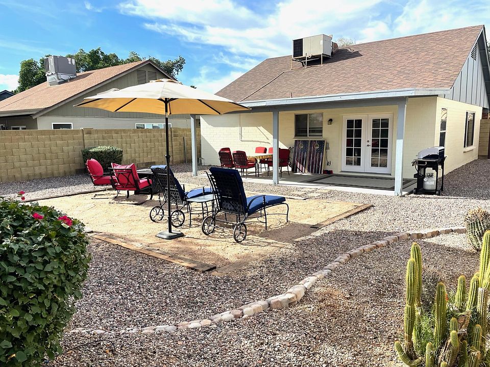 French doors open to large backyard with covered patio, gas BBQ grill, gas fire pit, lounge chairs and table seats six.