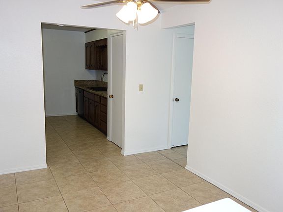 Looking into the dining area from front entry. Kitchen ahead with pantry door visible, and a coat closet door on the right