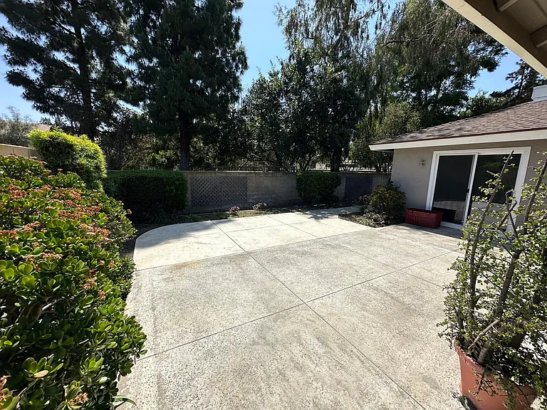 Back yard patio with primary bedroom sliding door on right.