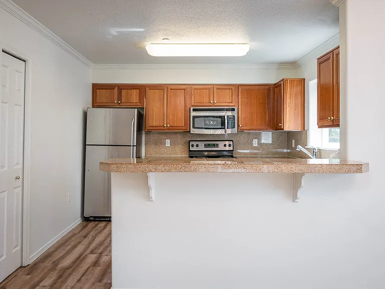Village at Main Street | 2x2 Kitchen with Wood Cabinetry with Eat In Counter Bar