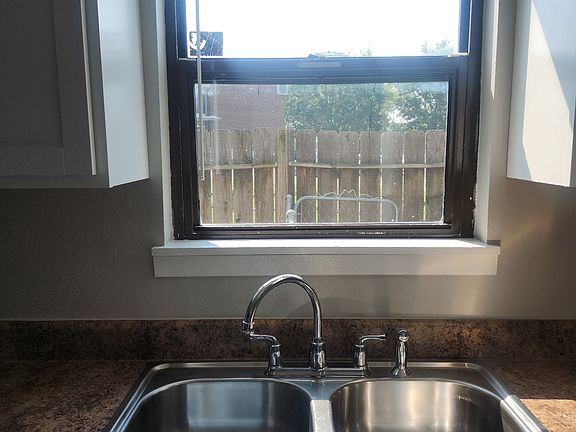 Looking out kitchen window to back fenced in area.