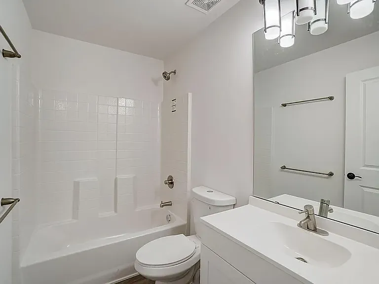 hall bath with satin nickel faucet and shower rod and groutless tub/shower combo