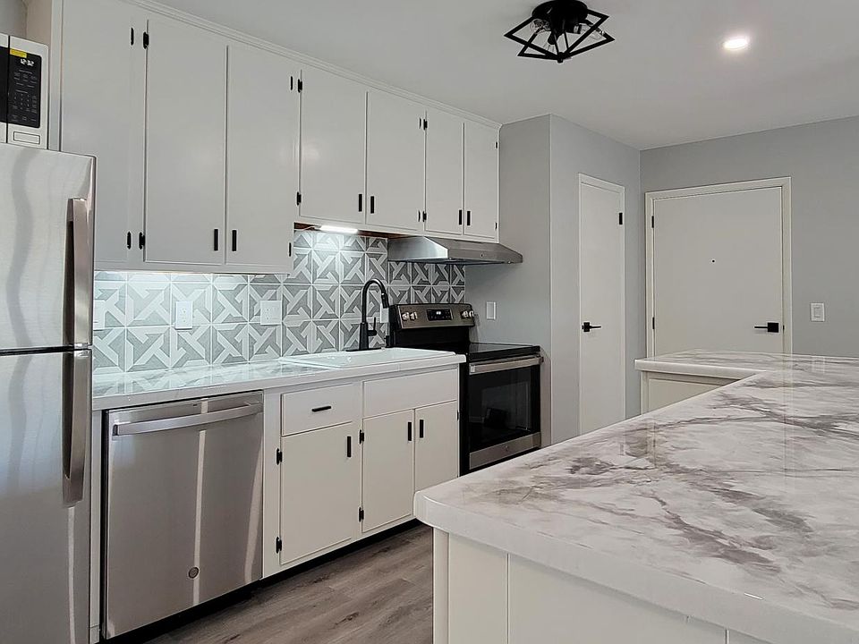 Fully remodeled kitchen includes white cast iron sink and breakfast bar