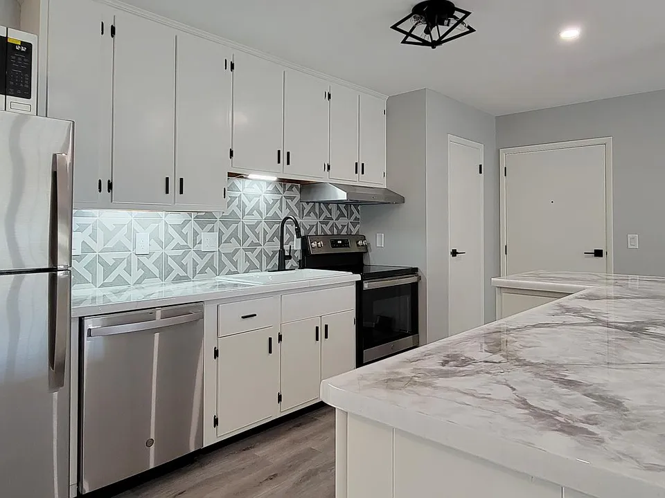 Fully remodeled kitchen includes white cast iron sink and breakfast bar
