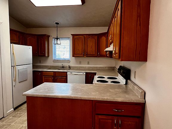 U shaped kitchen, plenty of cabinets, skylight above, food pantry, window above sink, dishwasher, large frig, stove, and dishwasher.