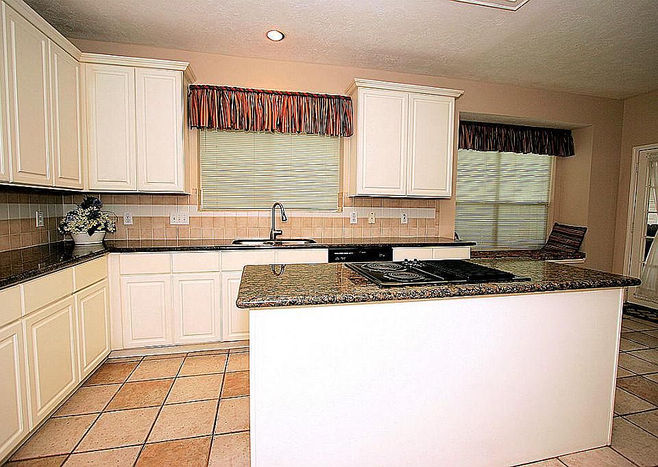 A VIEW OF THE KITCHEN AND BREAKFAST AREA.  LOOK AT ALL OF THAT CABINET AND COUNTER SPACE!
