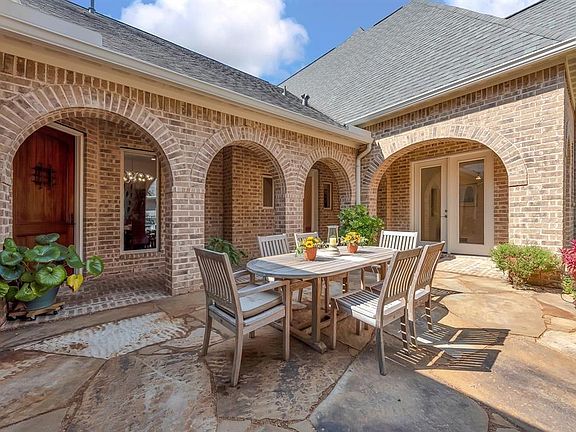 Charming courtyard entry welcomes guests and is the perfect place to entertain and dine al fresco. Brick archways surround the exterior of the flagstone courtyard adding architectural interest. The Guest Quarters is accessible through the French Door