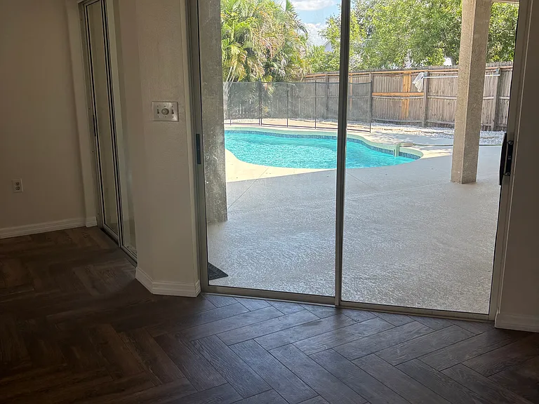 Kitchen nook area with sliders and view of swimming pool.