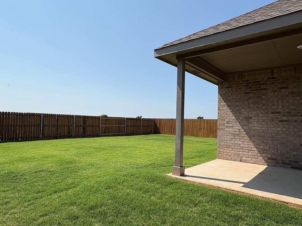 View of backyard from side showing covered patio and large backyard