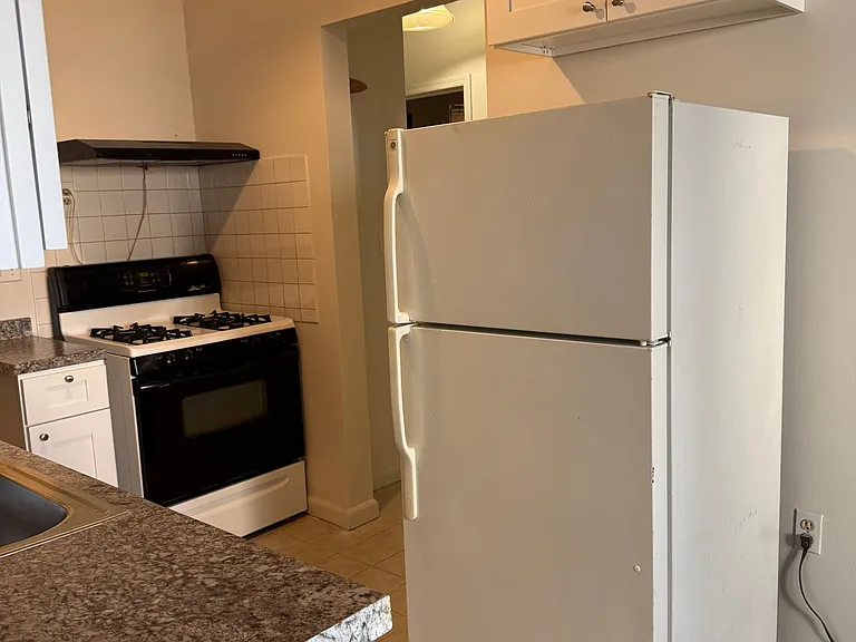 Kitchen with ceramic tile, new refrigerator, new cabinets, and refrigerator.