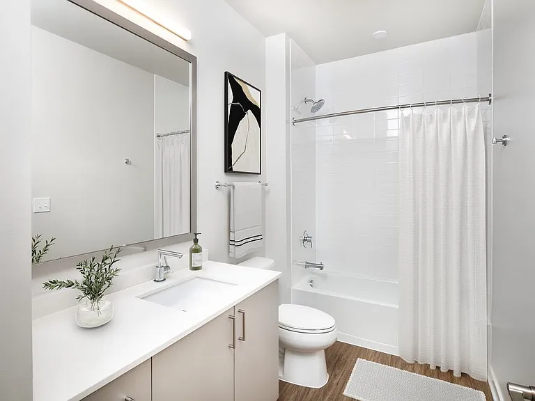 Design Collection II bath with cream quartz countertop, oak cabinetry, and hard surface flooring