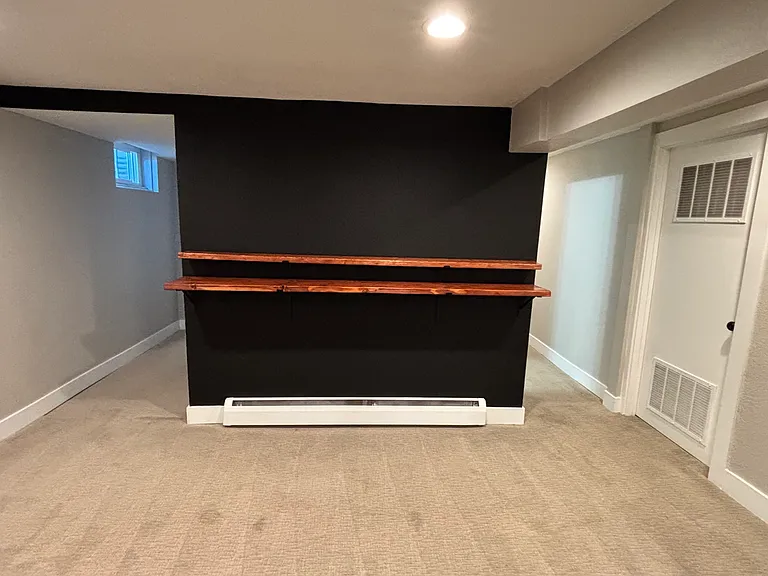 Living space includes new wooden shelves to complement bar stools or additional decor.